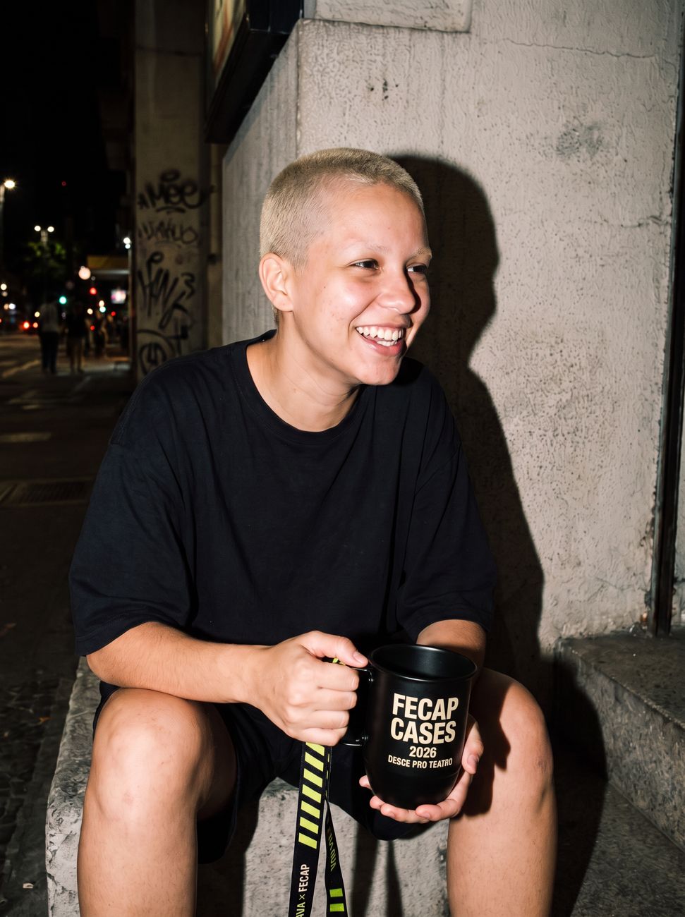 Estudante com a caneca na escada do teatro